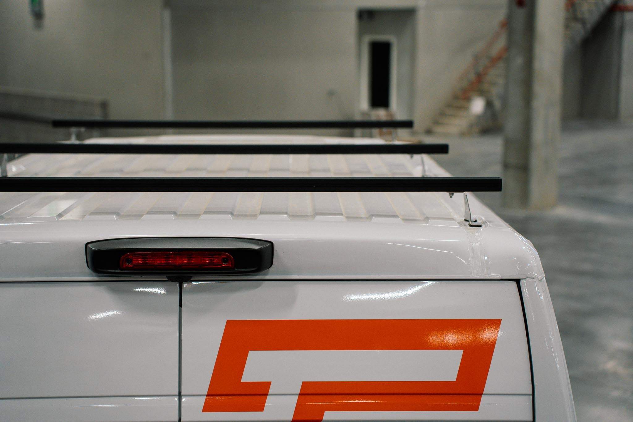 Zwarte T-Rack lastendragers gemonteerd op een bestelwagen