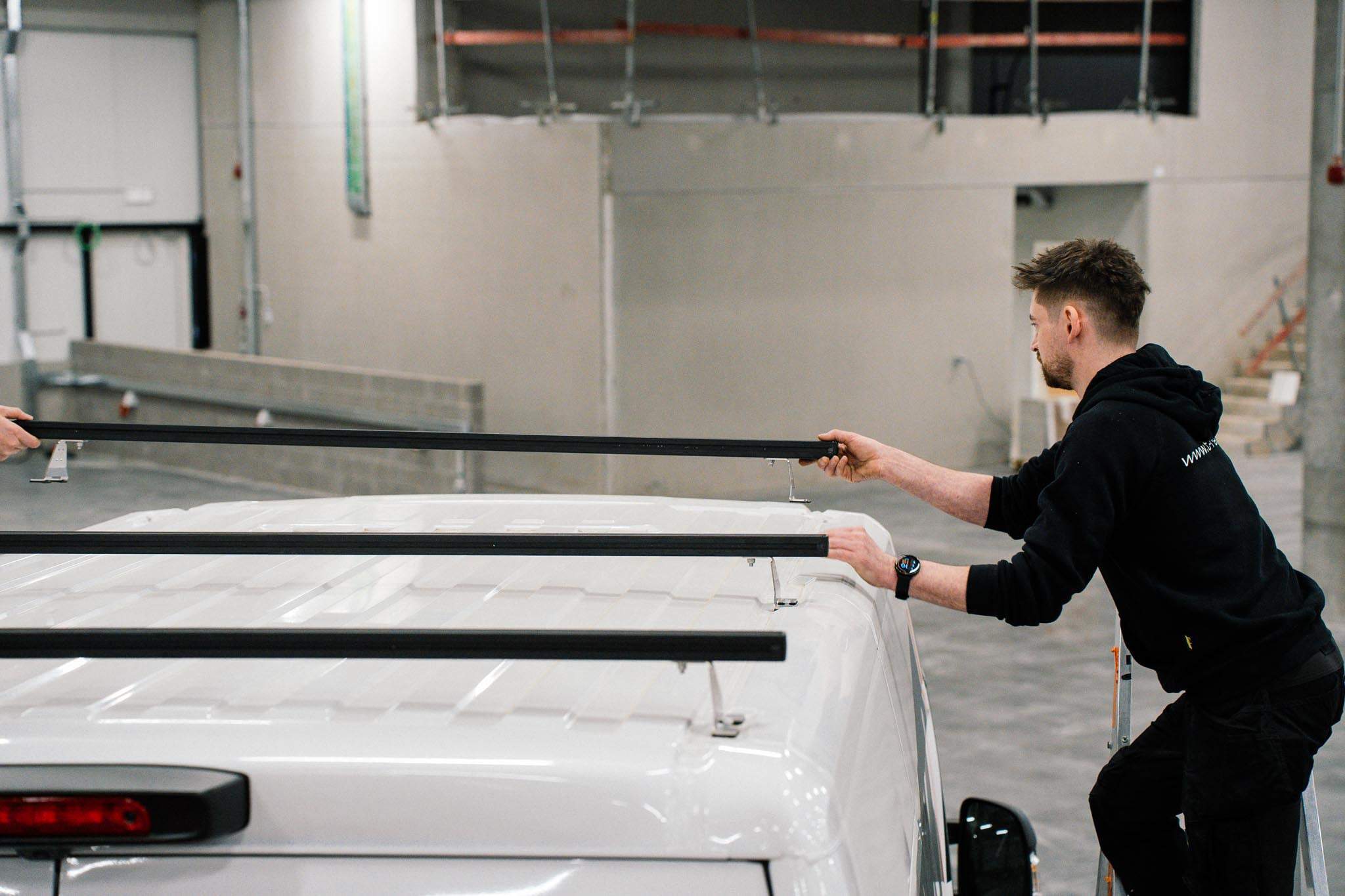 Montage van zwarte T-Rack dwarsliggers in het atelier
