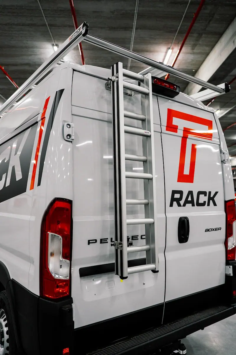 Grijze T-Rack schuifladder gemonteerd op een bestelwagen
